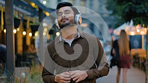 Indian Arabian male man teen gen z happy guy student businessman tourist in modern wireless headphones having fun listen