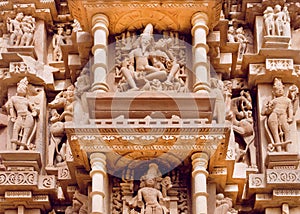 Indian architecture with figures of Lord Shiva and wife Parvati. Reliefs of historical temple in Khajuraho.