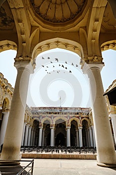 Indian architecture Thirumalai Nayakkar Mahal palace with flying birds through arch moment in Madurai photo