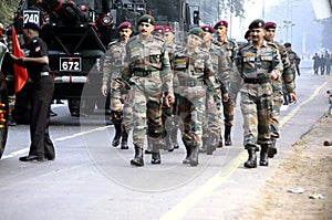 Army men in camouflage uniform casually marching past.