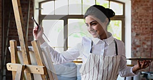 Indian artist woman engrossed in painting on canvas