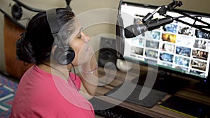 Indian asian caucasian musician woman girl in pink t-shirt singing and recording song at home studio. Desktop pc computer screen i