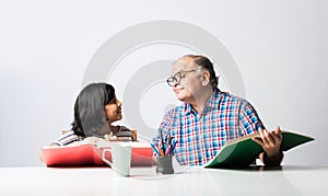 Indian asian Grandfather is teaching his granddaughter or grandaughter at home