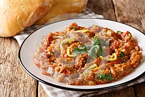 Indian Baingan Bharta eggplant, with tomatoes, garlic and spices close-up on a plate. horizontal