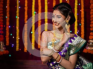 Indian Beautiful young girl wearing traditional sari making Flower rangoli for diwali or onam or Pongal Festival,Studio shot with