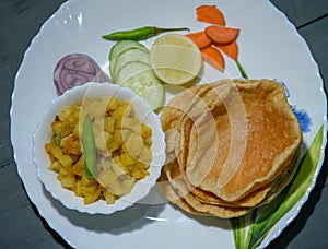 Indian Bengali Food Puri or Luchi with Aloo Sabji . Indian Poori is a bread deep fried in refined oil.