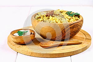 Indian biryani with chicken, yogurt and spices in a plate on a wooden table. New Year's, Christmas dish.