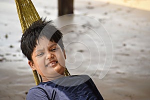 Indian boy relaxing on a hammock in the beach