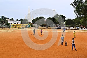 Indian boys playing cricket game on the playground in park.