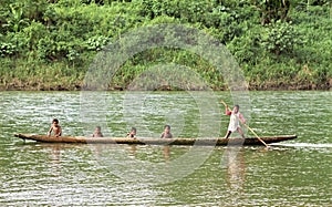 Indian boys sail with dugout canoe on river, Nicaragua