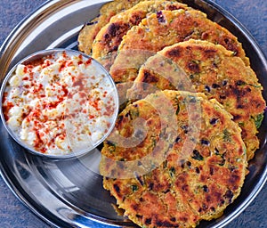 Indian breakfast koki flatbread with raita yogurt dip