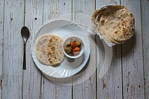 Indian breakfast menu paratha and sabji or vegetable masala served in a plate.