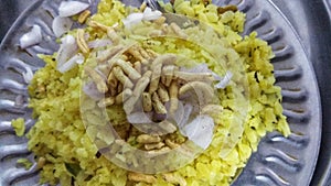 Indian Breakfast Poha garnished with sev and onions