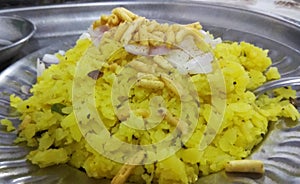 Indian Breakfast Poha garnished with sev and onions