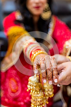 Indian bride with henna painted on arm and hands