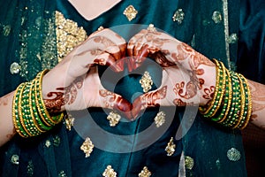 Indian bride making heart shape by her hands