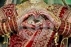 Indian bride making heart shape by her hands