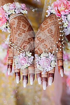 Indian bride's hands are decorated with henna flowers and designs in Indian traditional style