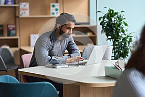 Indian business man student working or studying on laptop computer.