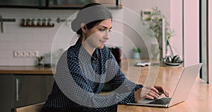 Indian business woman sitting indoor texting on laptop