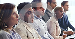 Indian businessman asking a question during a conference at a modern office. Group of coworkers attending a corporate