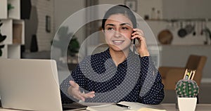 Indian businesswoman holding smart phone talking to client remotely