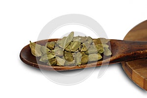 Indian Cardamom In Wooden Spoon. White Background