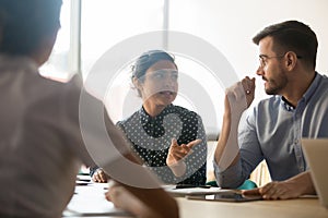 Indian and caucasian colleagues team people talking at corporate briefing