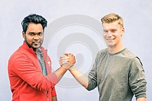Indian and caucasian men shaking hands in a modern handshake