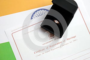 Indian Certificate of registration of marriage blank document and wedding ring on flag