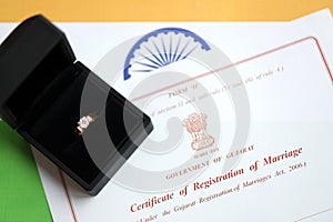 Indian Certificate of registration of marriage blank document and wedding ring on flag