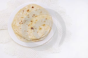 Indian chapati bread. chapati on a white plate on a white background. cooking in a dry pan photo