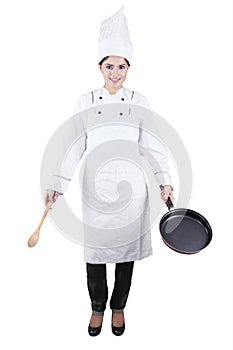 Indian chef holds spoon and frying pan