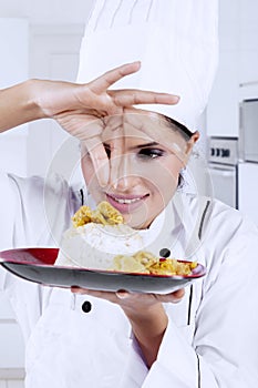 Indian chef sprinkling spices on a dish