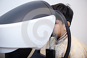 Indian child boy examining eyesight modern ophthalmology equipment in clinic. Patient kid male scan checkup iris examines