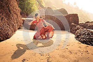 Beautiful indian woman dancer in traditional clothes at sunset