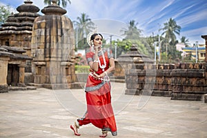 Indian classical dancer odissi dancer Mukteshvara Temple with sculptures in bhubaneswar, odisha, India