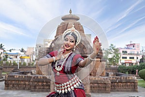 Indian classical Odissi dancer looks at the mirror during the Odissi dance posing in front of Mukteshvara temple.