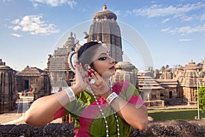 Indian classical odissi dancer posing at Lingaraja temple with sculptures in bhubaneswar. Indian Culture