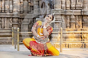 Indian classical odissi dancer wears traditional costume and posing in front of Konark Sun temple. Indian traditional girl.