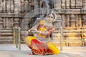 Indian classical odissi dancer wears traditional costume and posing in front of Konark Sun temple. Indian traditional girl.