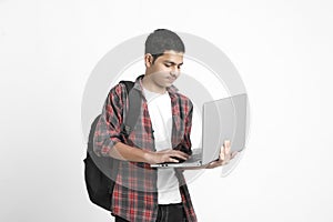 Indian college student using laptop on white background