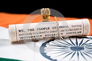 Indian constitution or Bharatiya Savidhana preamble with we the people of India writings paper placed on Indian flag - Concept of