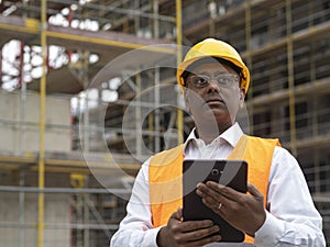 Indian construction worker using a digital tablet
