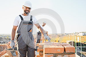 Indian construction workers work on the construction of a brick house. Construction of a brick wall