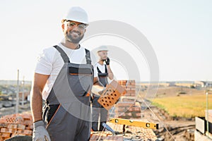 Indian construction workers work on the construction of a brick house. Construction of a brick wall