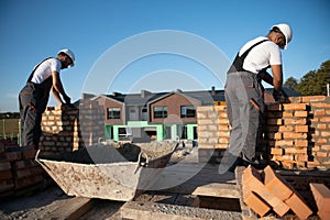 Indian construction workers work on the construction of a brick house. Construction of a brick wall