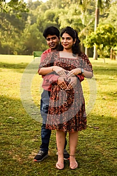 Indian couple posing for Maternity shoot pose for welcoming new born baby in Lodhi Garden in Delhi India, Maternity photo shoot