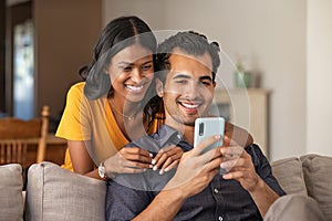 Indian couple using smartphone at home