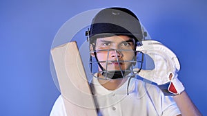 Indian cricket batsman with helmet, bat, and gloves in hands, looking at the camera - Sports